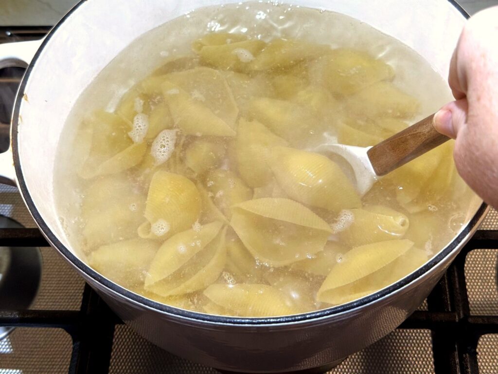 Jumbo pasta shells boiling in a large pot of water