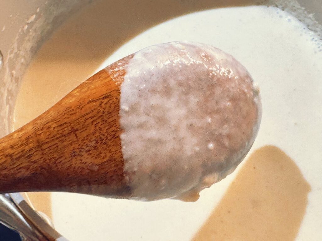 Cheese sauce coating the back of a wooden spoon