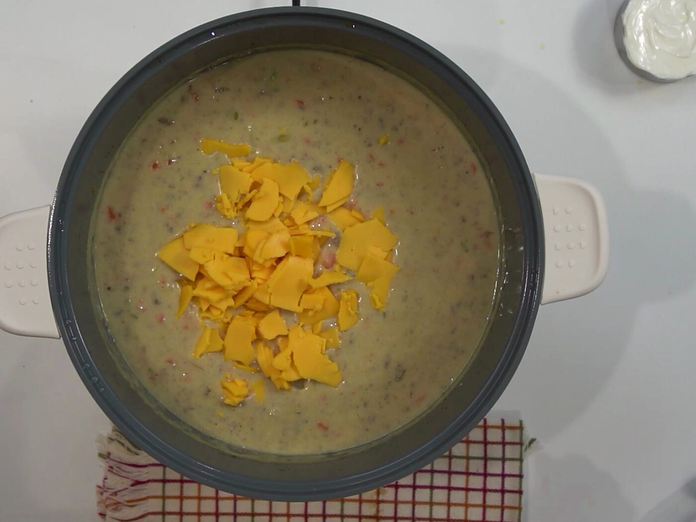 Torn pieces of yellow American cheese added to the creamy soup