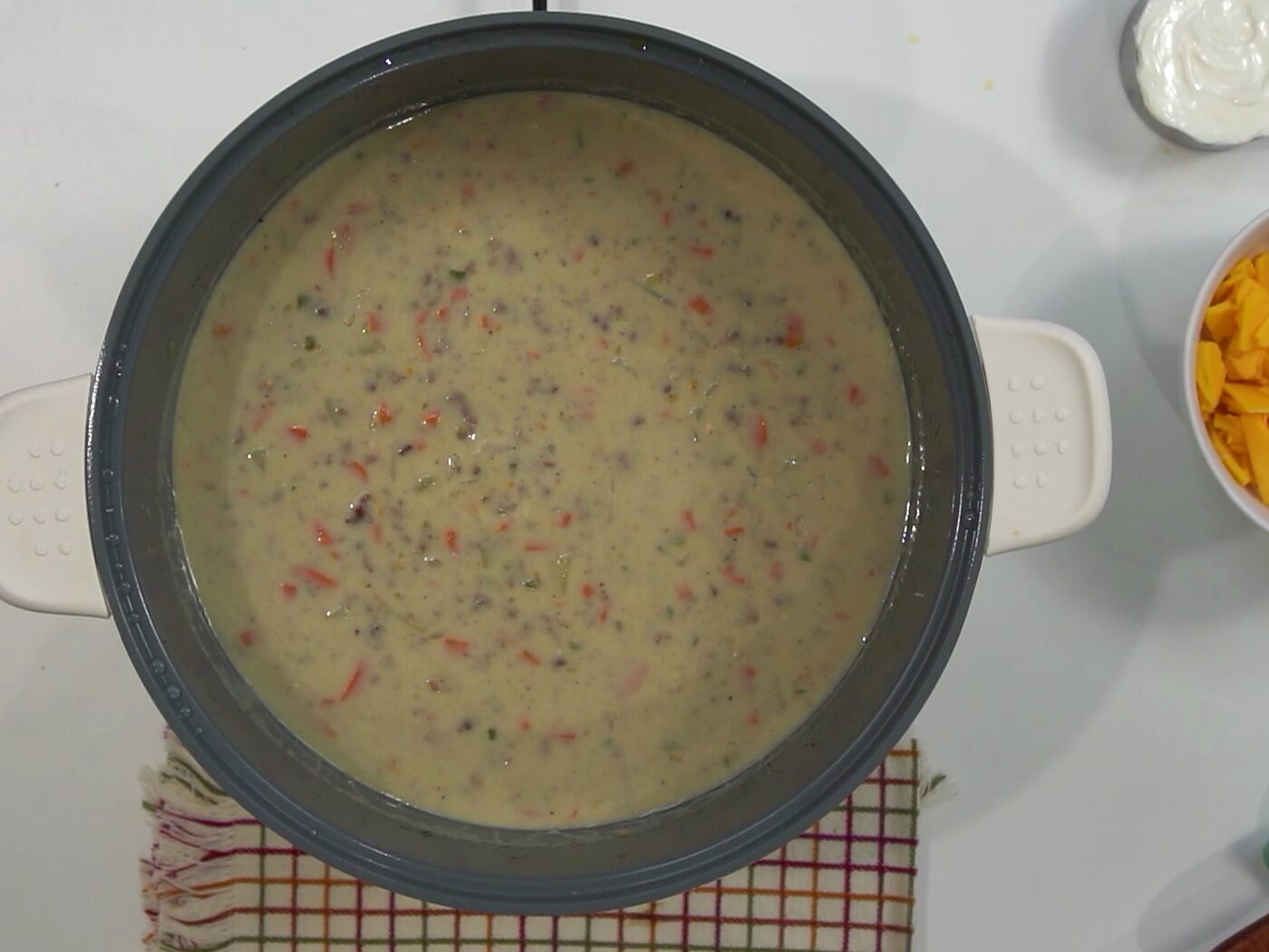 Overhead view of creamy cheeseburger soup in a pot before the cheese goes in