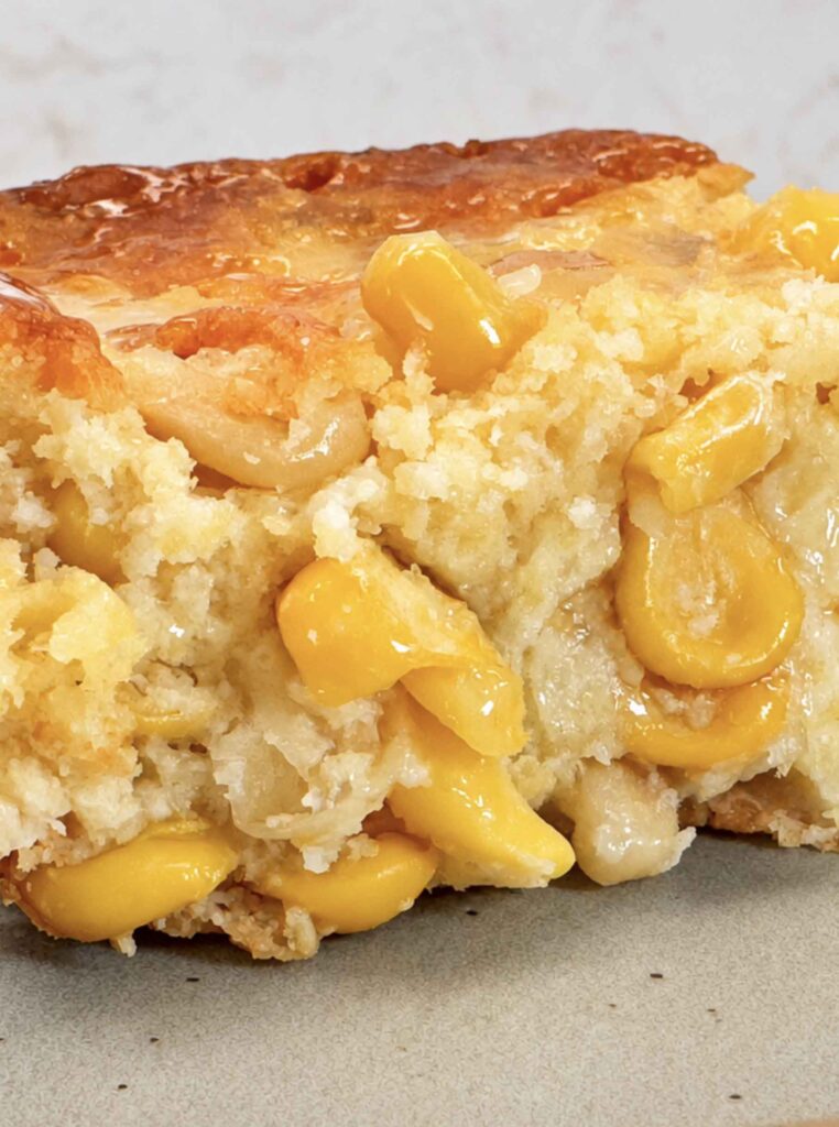 Close-up of the golden, baked cream corn casserole with corn kernels showing
