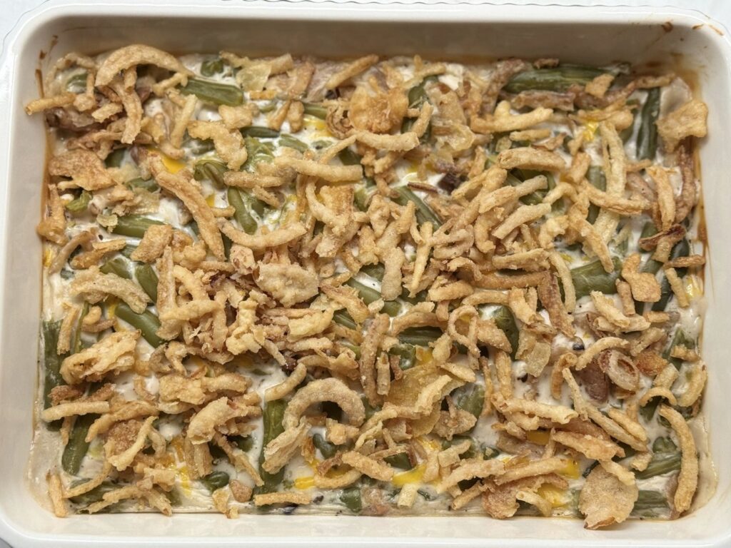 Green bean casserole covered with fried onions, ready to go back into the oven