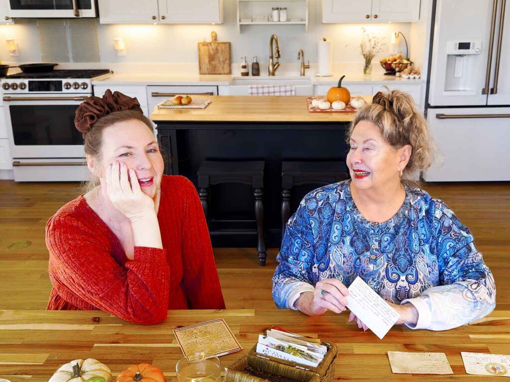 Jennifer Maker and her mom laughing at the kitchen table while looking through Mom's vintage recipe box