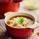 Bowl of lasagna soup with cheese and basil on top