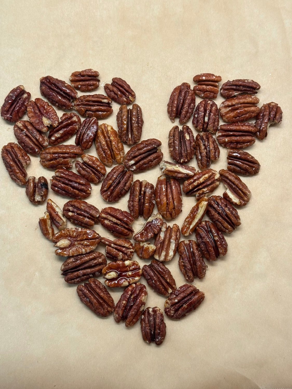 Maple pecans arranged in a heart shape on parchment paper