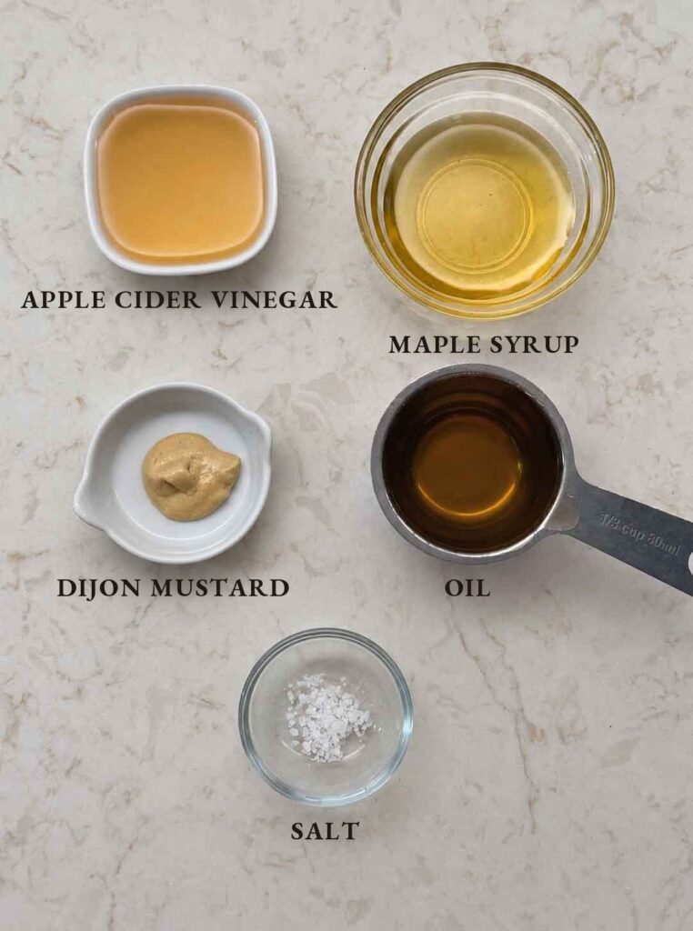 Labeled ingredients for maple vinaigrette: apple cider vinegar, maple syrup, Dijon mustard, oil, and salt
