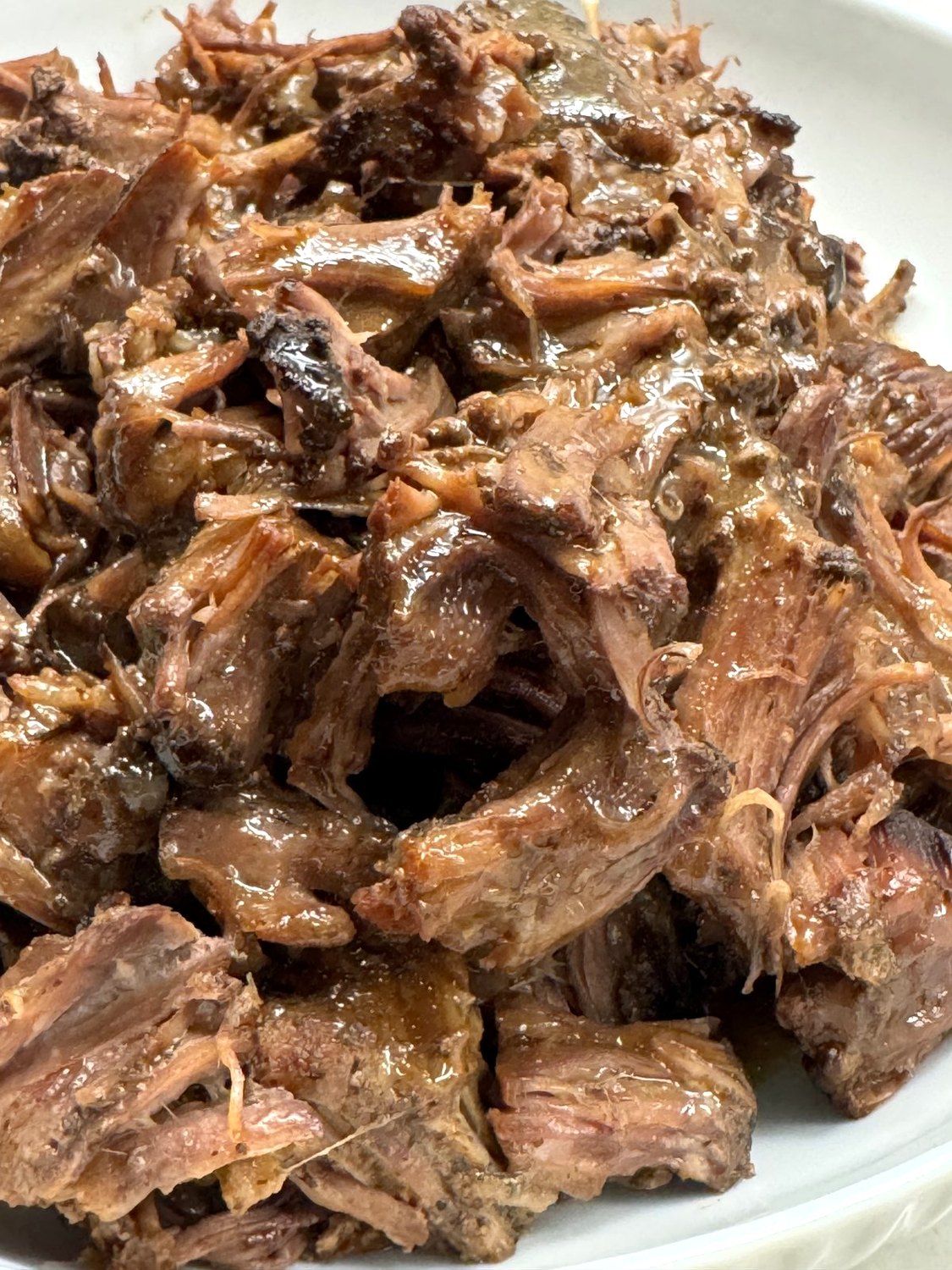 Close-up of tender shredded Mississippi pot roast with pepperoncini