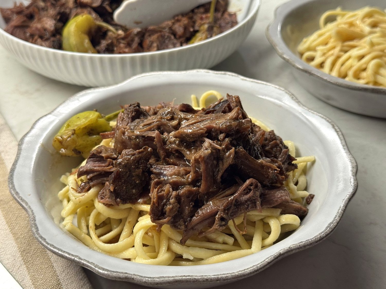 Mississippi pot roast with glossy brown gravy over spaetzle