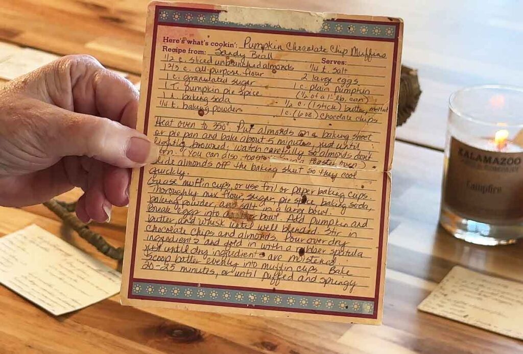 Jennifer Maker's mom holding her handwritten pumpkin chocolate chip muffin recipe card
