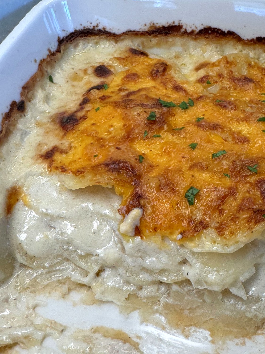 Inside view of scalloped potatoes showing tender, creamy potato layers under a golden cheddar top