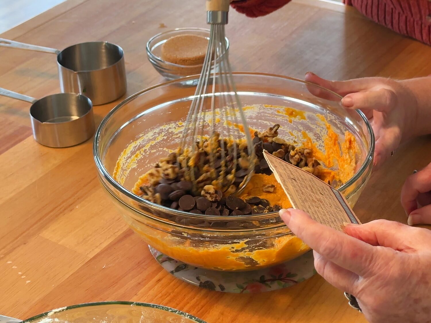 Whisking chocolate chips and walnuts into the pumpkin and egg mixture