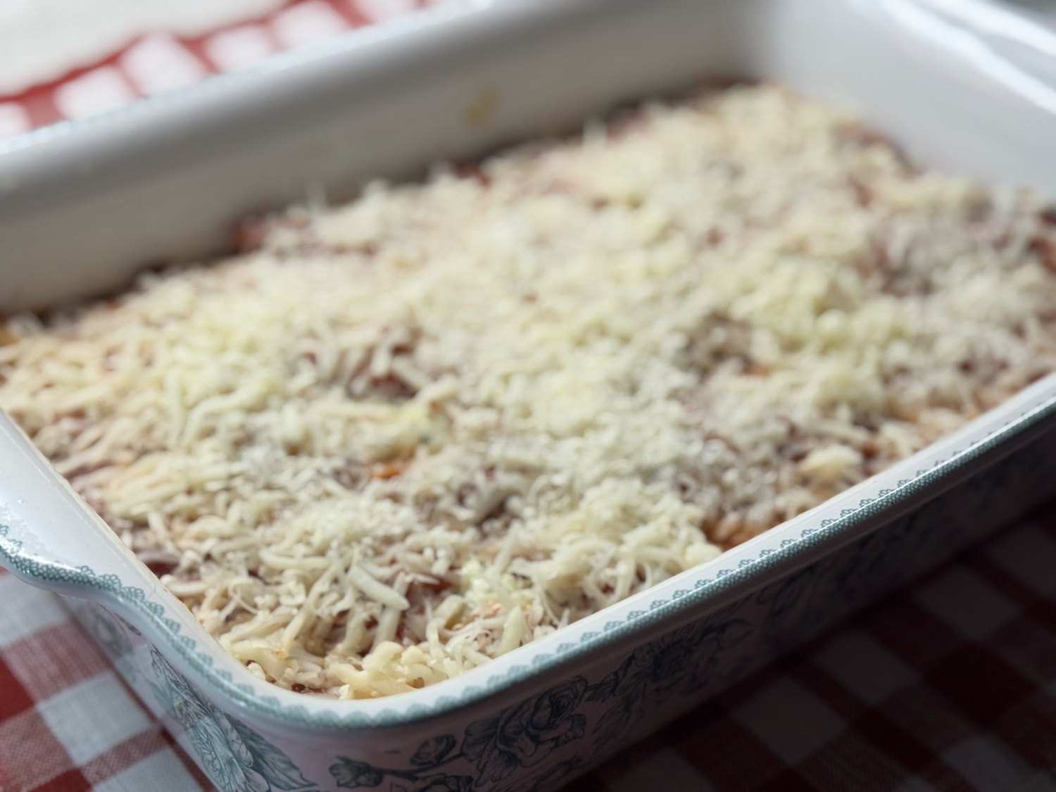 Stuffed shells covered with shredded mozzarella and Parmesan, ready to go back in the oven