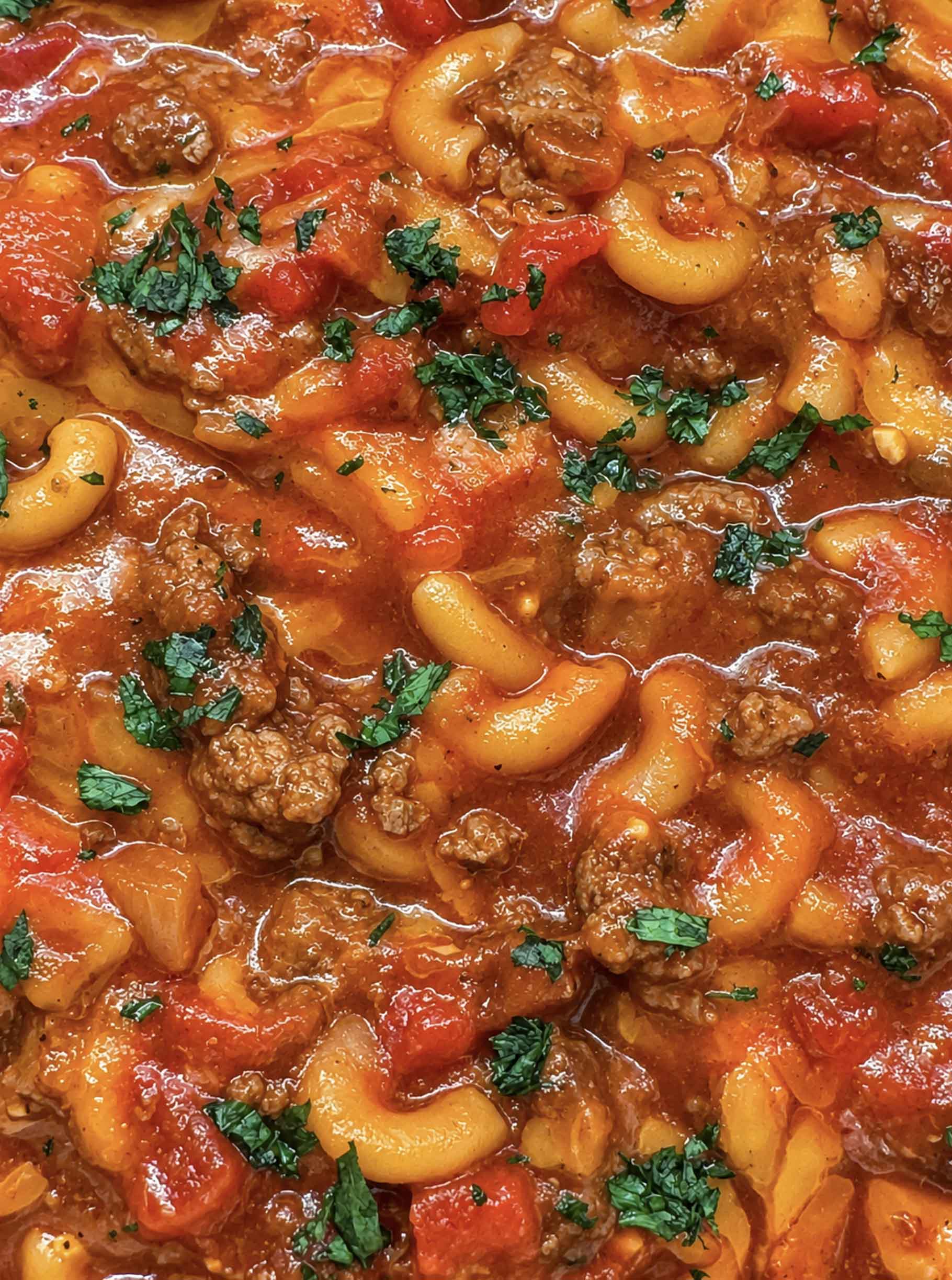 Close-up of venison goulash with elbow macaroni, ground venison, diced tomatoes, and chopped parsley