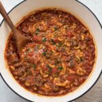 Big pot of venison goulash with a spoon in it